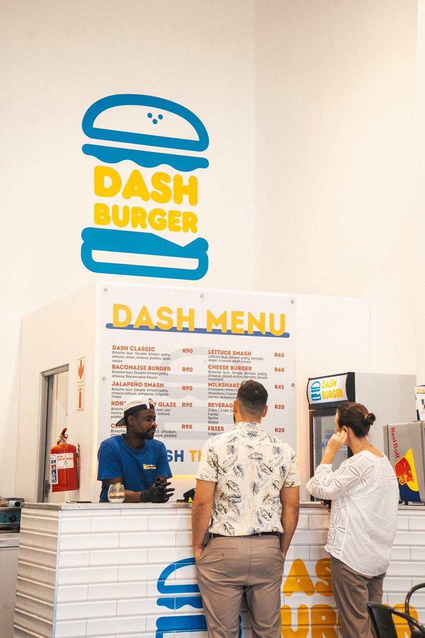 DashBurger's bright white-tiled counter with the blue and yellow logo above